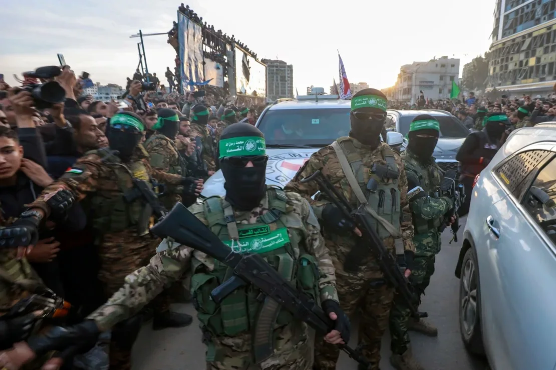 Militantes del ala militar de Hamas, las Brigadas Qassam, escoltan un vehículo de la Cruz Roja para recoger rehenes israelíes en la ciudad de Gaza el domingo. Abed Hajjar/AP