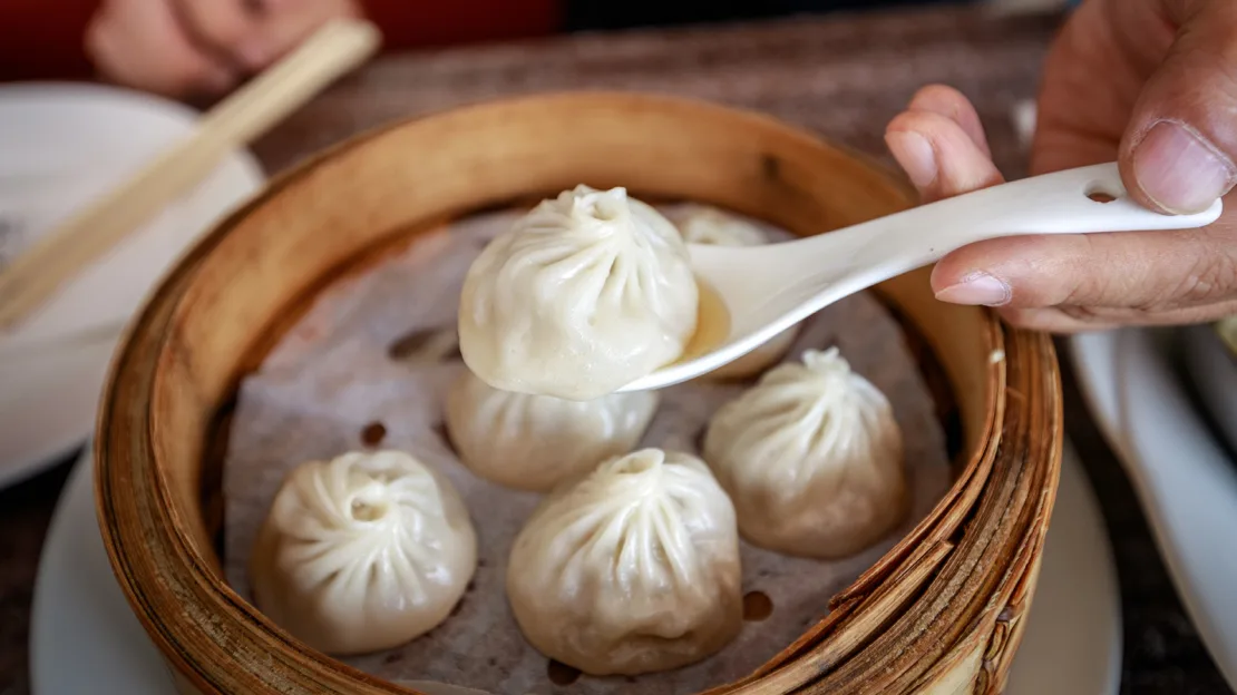 Utilice una cuchara para recoger la sopa derramada de un xiaolongbao. Parque Yooran/Adobe Stock