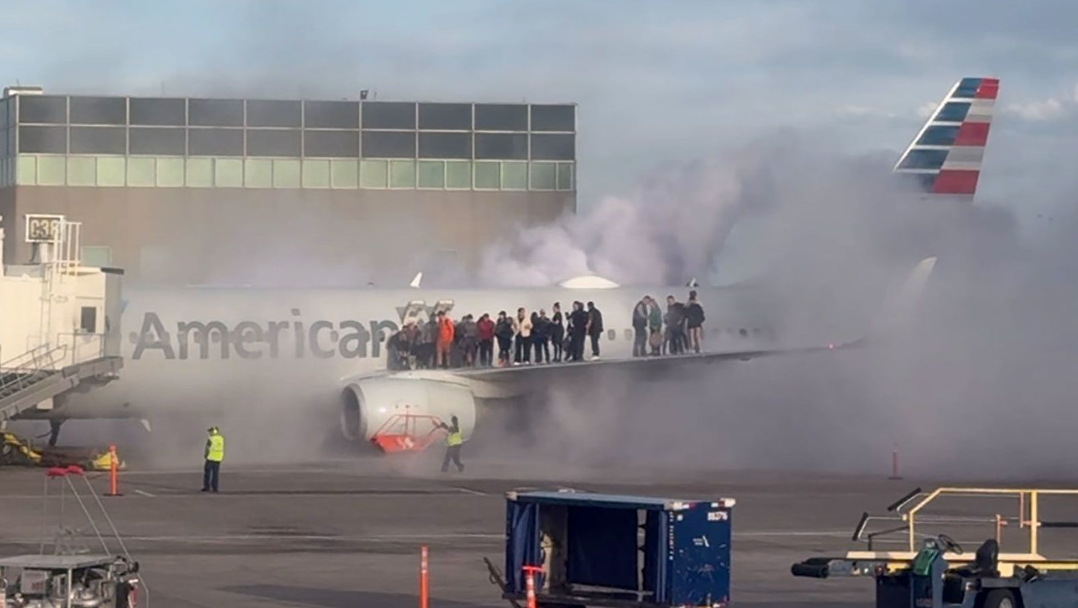 Se ve a pasajeros de un avión saliendo del avión y parándose en el ala mientras el humo se eleva a su alrededor en el aeropuerto de Denver/@steve_schilsky/X vía CNN Newsource