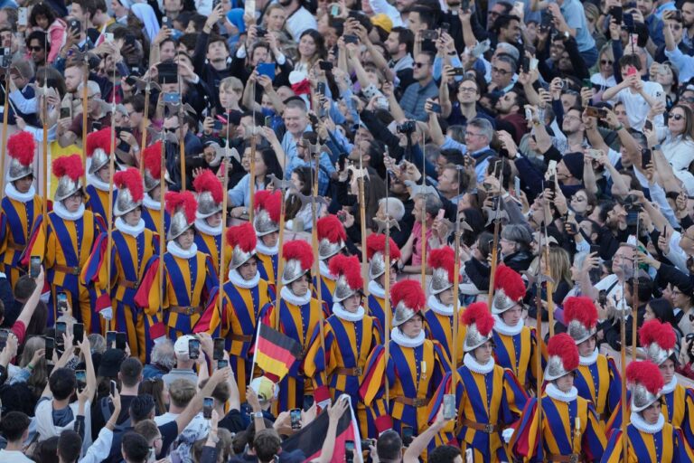 La Guardia Suiza y la banda marchan por la Plaza de San Pedro entre la multitud que espera conocer al nuevo papa