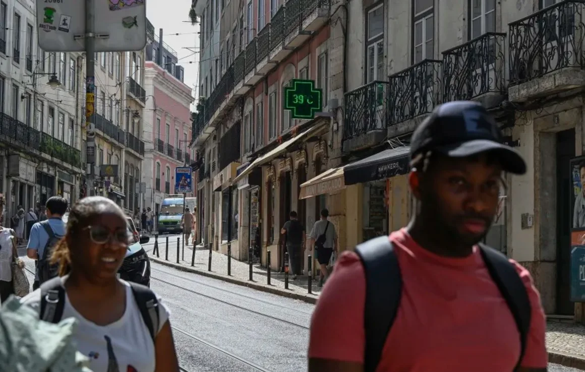 Los peatones pasan junto a un cartel de farmacia que muestra 39 ºC mientras las altas temperaturas azotan Lisboa, Portugal, el 28 de junio de 2025. Horacio Villalobos/Corbis News/Getty Images