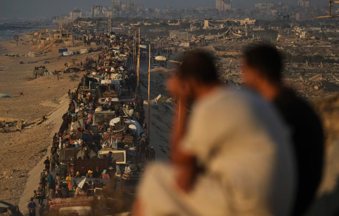 Palestinos desplazados huyen del norte de Gaza a pie y en vehículos por la carretera costera hacia el sur del enclave este lunes. Abdel Kareem Hana/AP