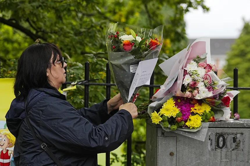 Una mujer coloca ramos de flores y mensajes de homenaje en la sinagoga de la Congregación Hebrea de Heaton Park en Crumpsall el viernes. Peter Byrne/PA/AP