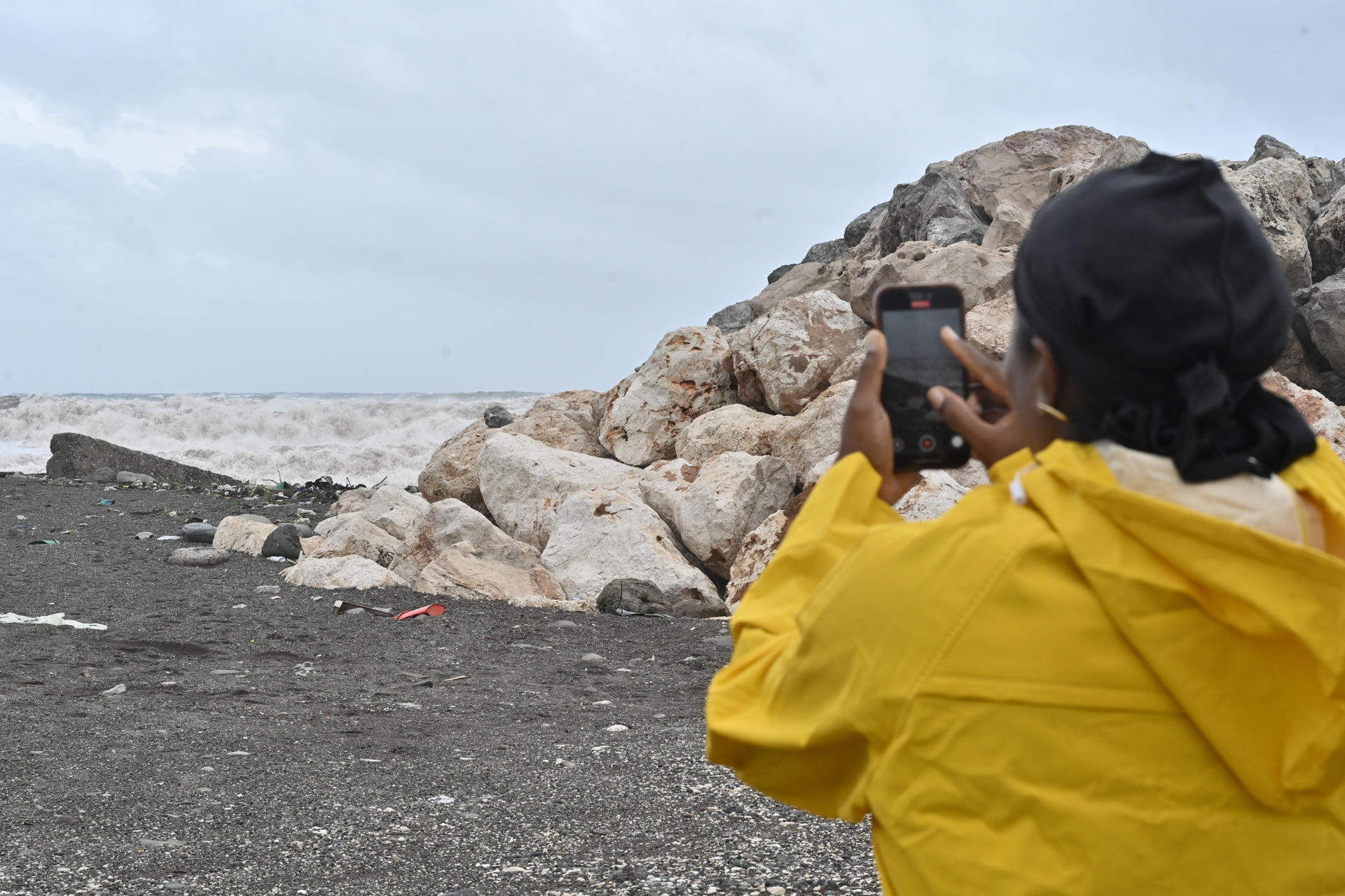 Una persona toma una fotografía a las olas provocadas por el paso del huracán Melissa este martes, en Kingston (Jamaica). EFE/Rudolph Brown