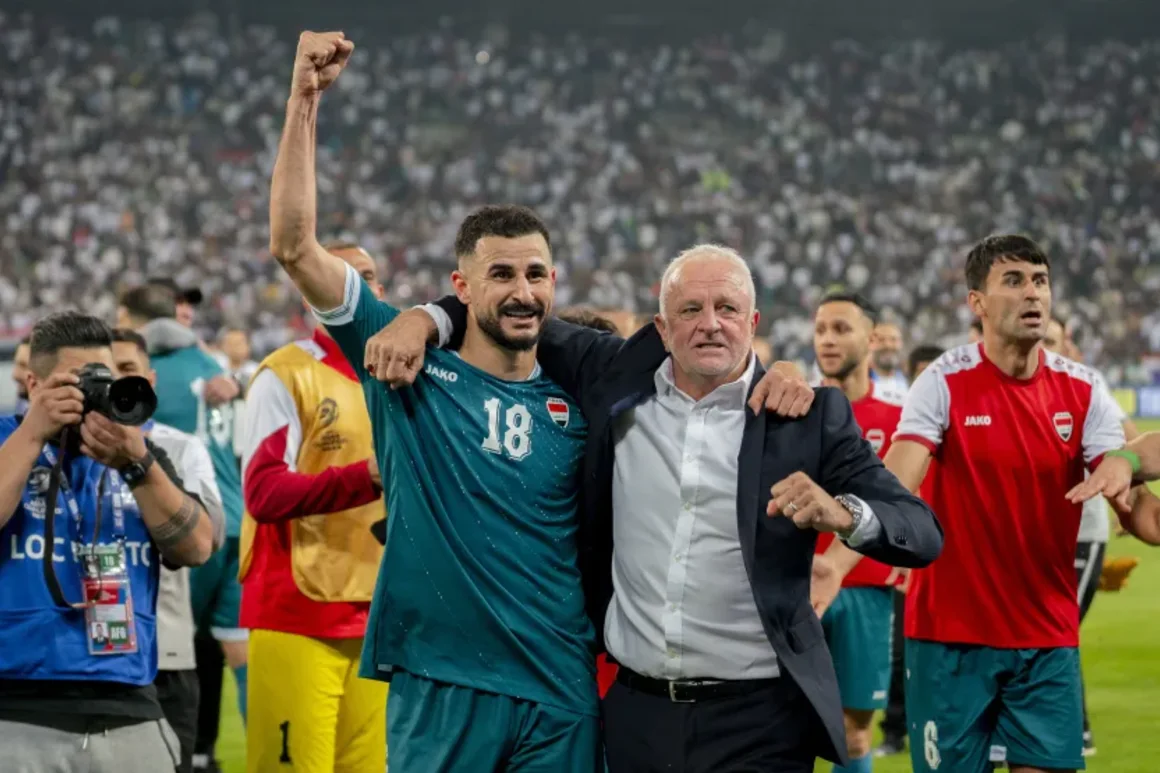 Aymen Hussein de Iraq levanta el puño junto al entrenador en jefe Graham Arnold mientras celebran la victoria sobre los Emiratos Árabes Unidos en noviembre. Tiba Sadeg/AFP/Getty Images