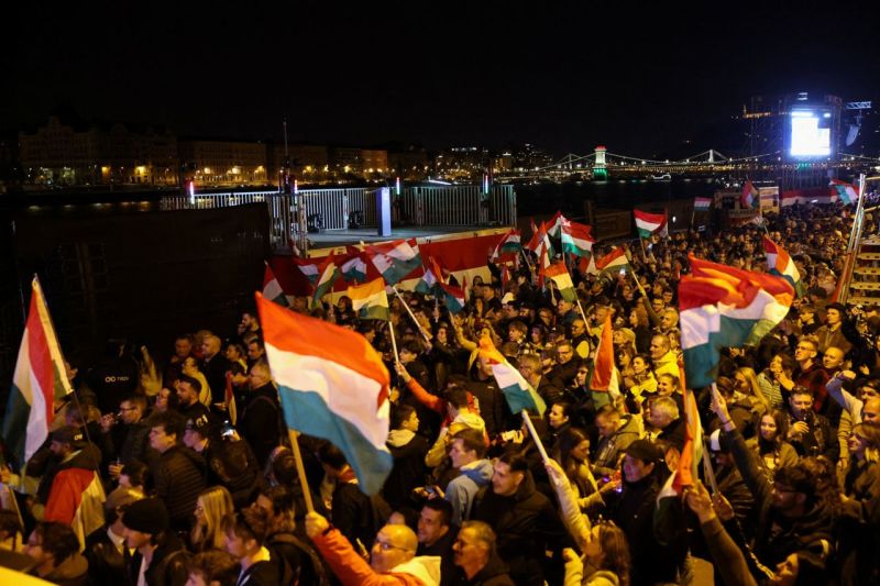 Partidarios de Peter Magyar, líder del partido opositor Tisza, alzan banderas húngaras tras el anuncio de los resultados parciales de las elecciones parlamentarias en Budapest, el domingo. Leonhard Foeger/Reuters