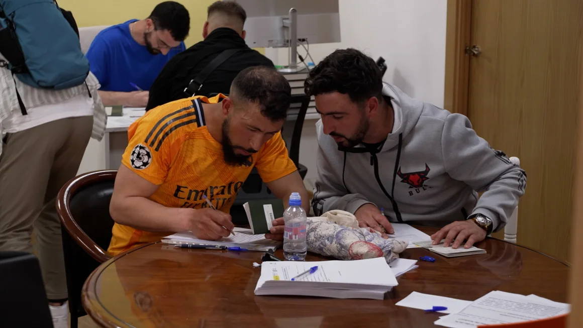 Dos migrantes completan formularios durante el primer día del proceso de regularización extraordinaria en Madrid. CNN
