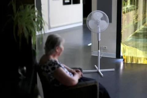 Un ventilador está instalado mientras una residente anciana permanece sentada en una residencia de ancianos en Les Sorinières, cerca de Nantes, Francia, al tiempo que suben las temperaturas el lunes 22 de junio de 2026. Stephane Mahe/Reuters