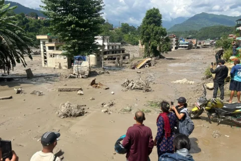 Varias personas observan casas parcialmente sumergidas en agua lodosa tras las inundaciones repentinas en Trishuli Bazar, en el distrito de Nuwakot, Nepal, el miércoles.Prakash Mathema/AFP/Getty Images