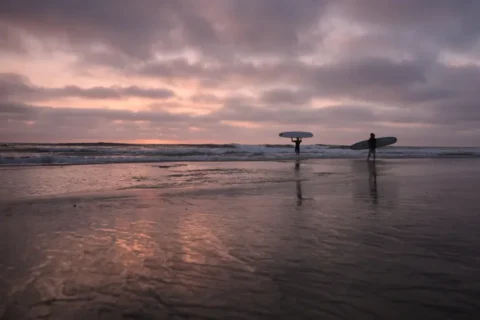 Unos surfistas se adentran en el océano Pacífico al atardecer en Encinitas, California, el 1 de octubre. Gregory Bull/AP