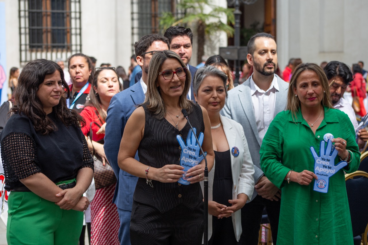 La diputada Erika Olivera, la ministra Jeannette Jara y Claudia Salgado posan para una foto durante la jornada de promulgación de la Ley Karin.