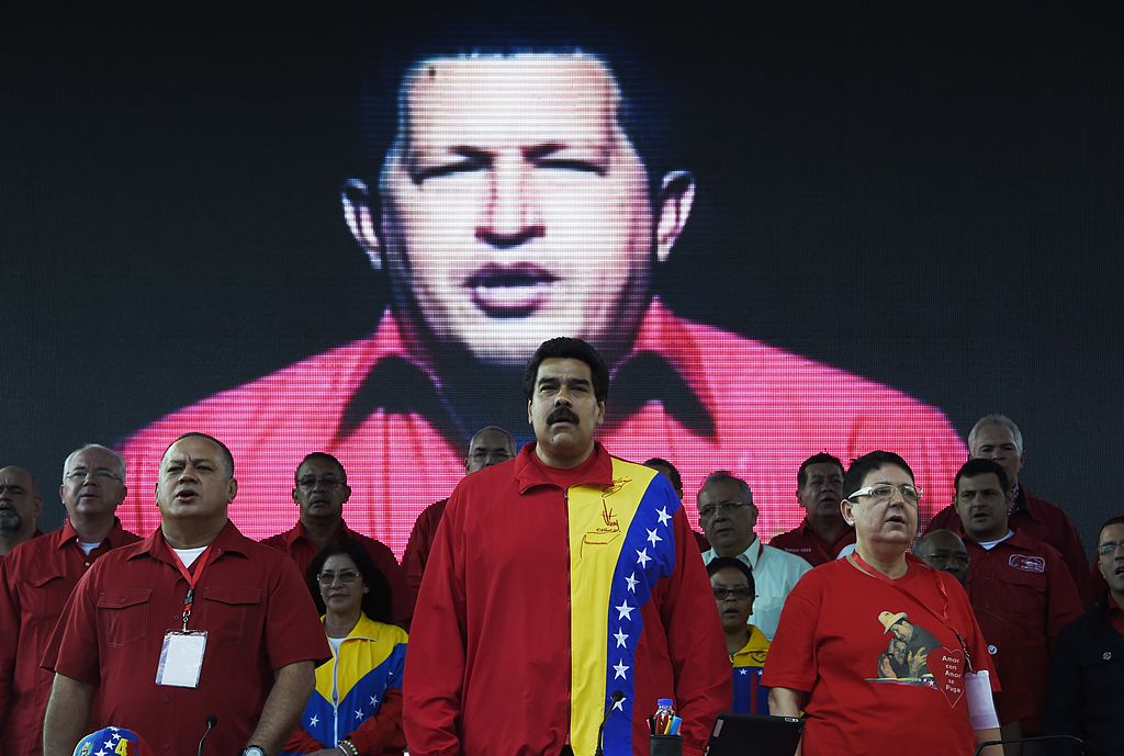 El presidente venezolano Nicolás Maduro (C) y el presidente del Parlamento Diosdado Cabello (2-izq) son vistos entre otras autoridades e invitados durante el congreso anual del Partido Socialista Unido de Venezuela (PSUV) el 31 de julio de 2014, en el Cuartel de la Montaña de Caracas. , donde reposan los restos del expresidente venezolano Hugo Chávez (en pantalla). (Crédito: JUAN BARRETO/AFP/Getty Images)