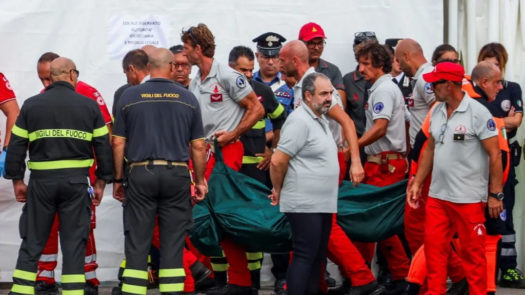 El personal de rescate transporta una bolsa para cadáveres a tierra mientras prosigue la búsqueda del superyate naufragado Bayesian. (Crédito: Louiza Vradi/Reuters)