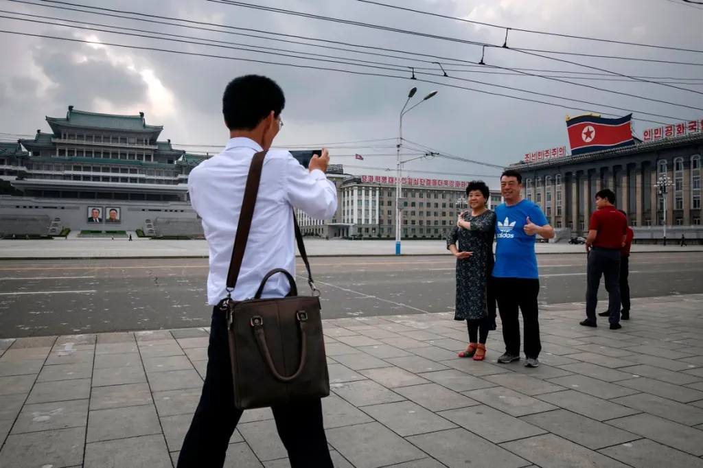 Turistas chinos posan para fotografías en la plaza Kim Il Sung en 2019. Crédito: Ed Jones/AFP/Getty Images.