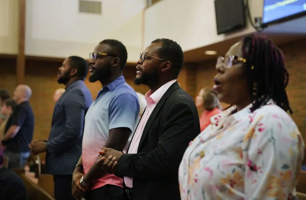 Miembros de la comunidad haitiana en Springfield, Ohio, de pie durante el culto en una iglesia cristiana local el 15 de septiembre de 2024. (Crédito: Jessie Wardarski/AP)