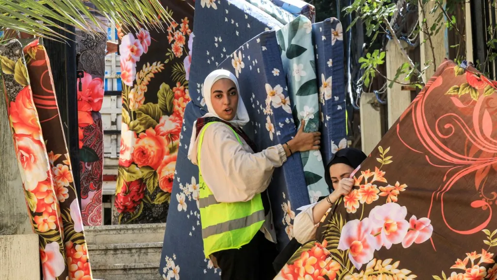 Voluntarios transportan colchones para personas desplazadas por el conflicto del sur del Líbano en un centro de recepción temporal en la ciudad sureña de Sidón el 25 de septiembre. (Crédito: Mahmud Zayyat/AFP/Getty Images)