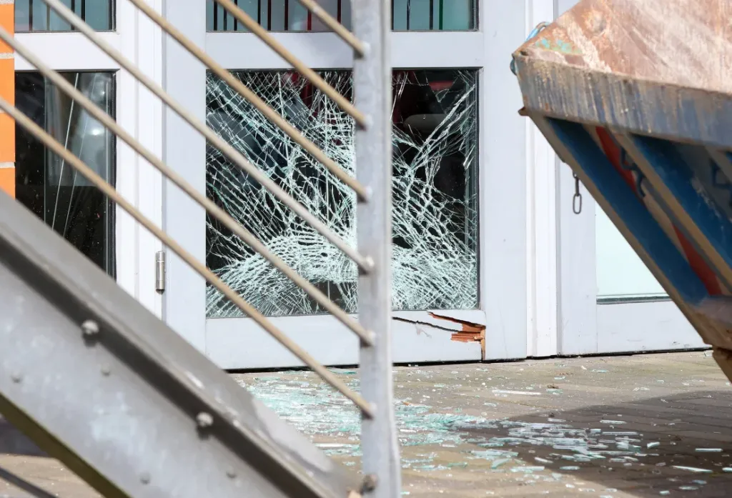 Se puede ver una ventana rota en la puerta de una sucursal de Sparkasse en un centro comercial en Schenefeld, Alemania, el 22 de abril de 2024. (Crédito: Bodo Marks/Picture Alliance/Getty Images/Archivo)