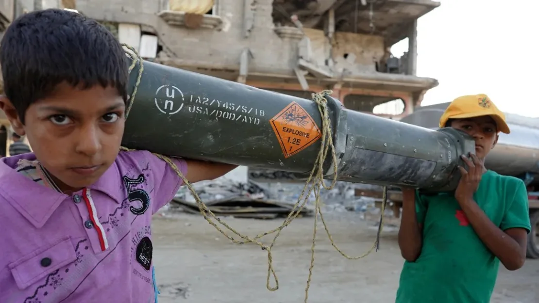 Niños palestinos transportan un contenedor de munición estadounidense vacío en Khan Younis, en el sur de Gaza, el 16 de mayo de 2024. AFP/Getty Images