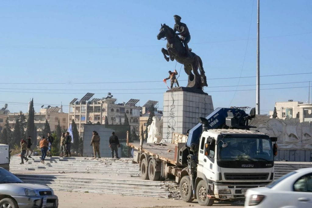 Los combatientes rebeldes se preparan para derribar la estatua ecuestre de Bassel-al-Assad, hermano mayor del presidente Bashar al-Assad. Muhammad Haj Kadour/AFP/Getty Images vía CNN Newsource