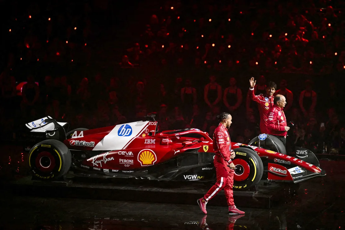 Hamilton sale al escenario con el nuevo coche Ferrari, junto al director del equipo, Frédéric Vasseur, y el piloto Charles Leclerc. Ben Stansall/AFP/Imágenes Getty