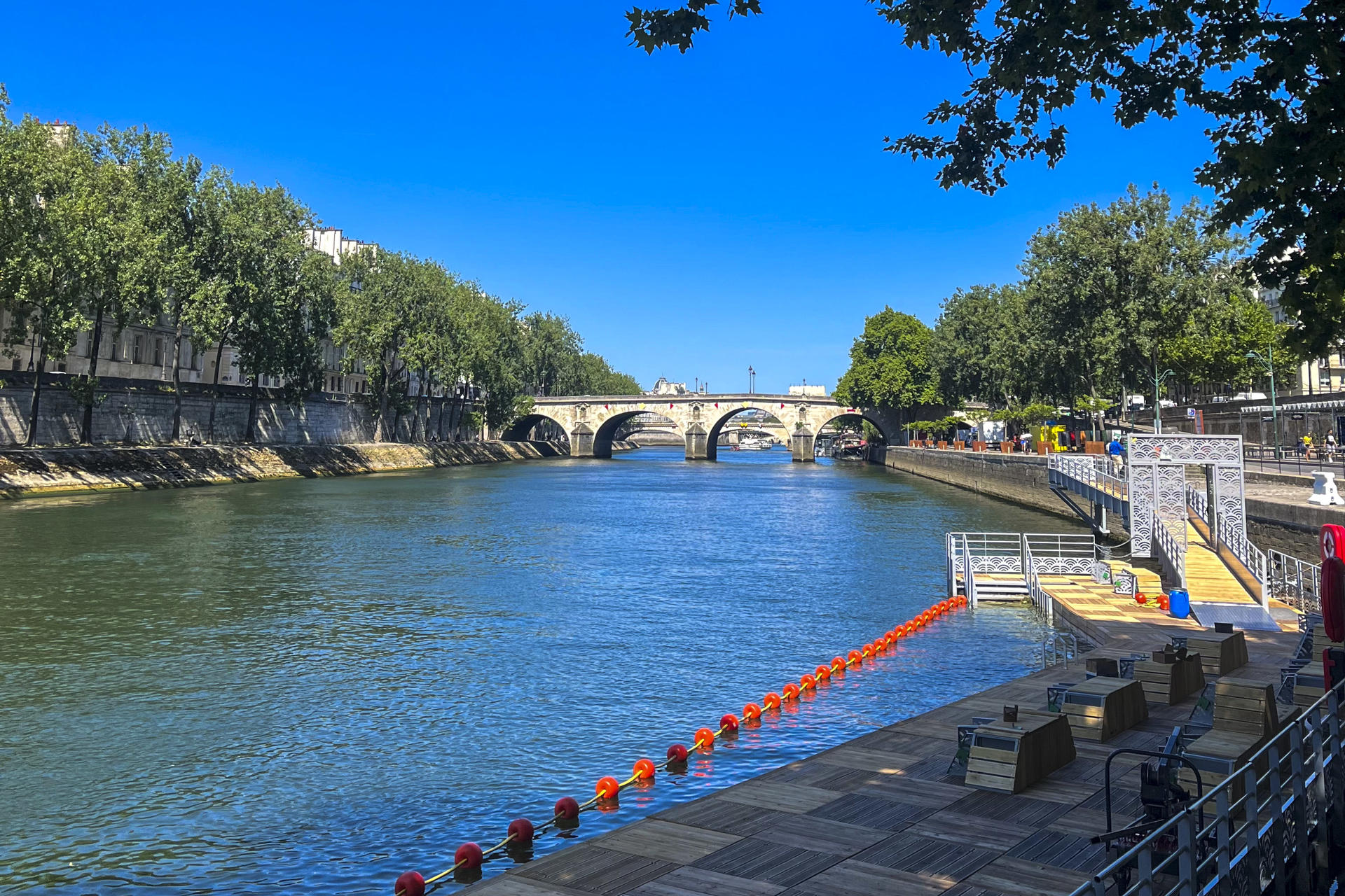 Las plataformas de madera y las boyas naranjas que conforman la nueva zona de baño en el río Sena en Bras Marie frente la Isla Saint-Louis, entre el puente Sully y el puente Marie (al fondo). Este es uno de los tres espacios habilitados para nadar en el Sena. EFE/ Val Torres