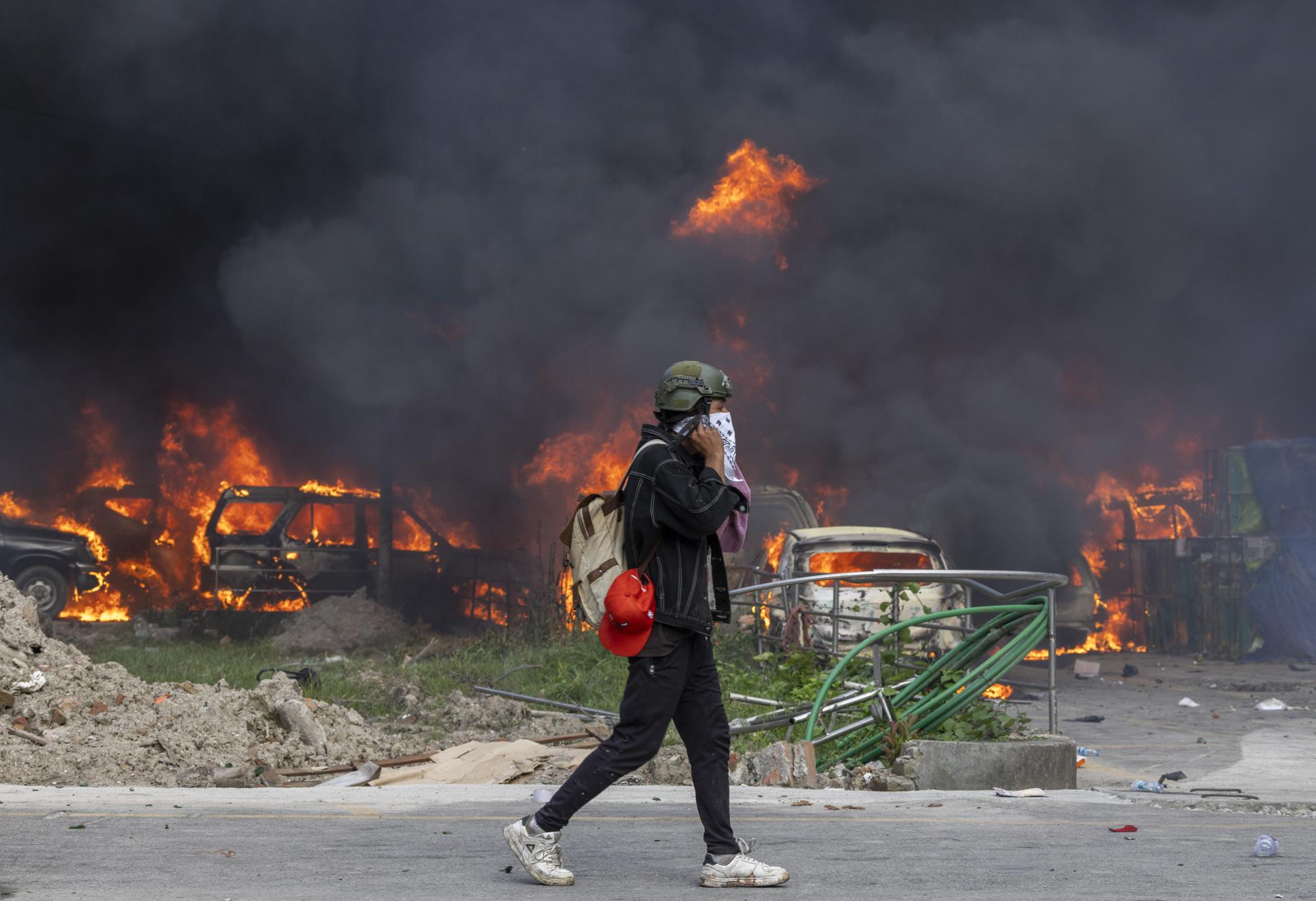 Un hombre camina cerca de vehículos en llamas frente al edificio de la Corte Suprema, que fue incendiado durante violentas manifestaciones en Katmandú, Nepal, el 9 de septiembre de 2025. Al menos 19 personas murieron y decenas resultaron heridas el 8 de septiembre durante las manifestaciones contra la corrupción y la prohibición gubernamental de las redes sociales. (Protestas) EFE/EPA/NARENDRA SHRESTHA