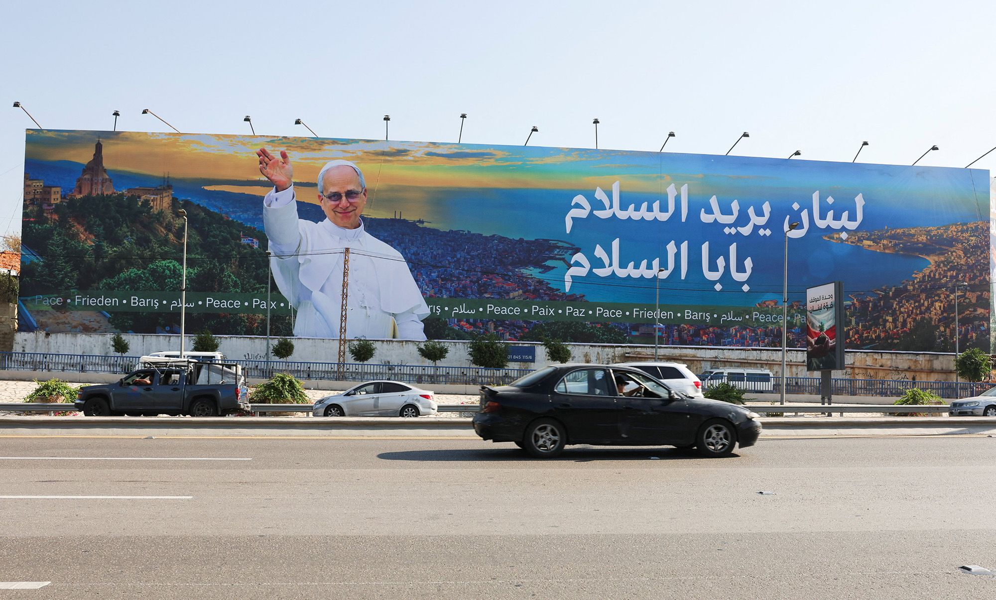 Un automóvil circula cerca de un cartel que representa al Papa León XIV en Beirut antes de su visita planeada al Líbano. Mohamed Azakir/Reuters