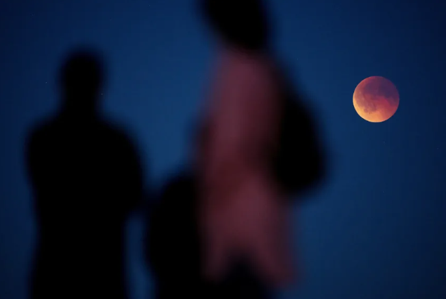 La gente observa una luna de sangre durante un eclipse lunar total en Køge, Dinamarca, en septiembre. Mads Claus Rasmussen/Ritzau Scanpix Dinamarca/Reuters