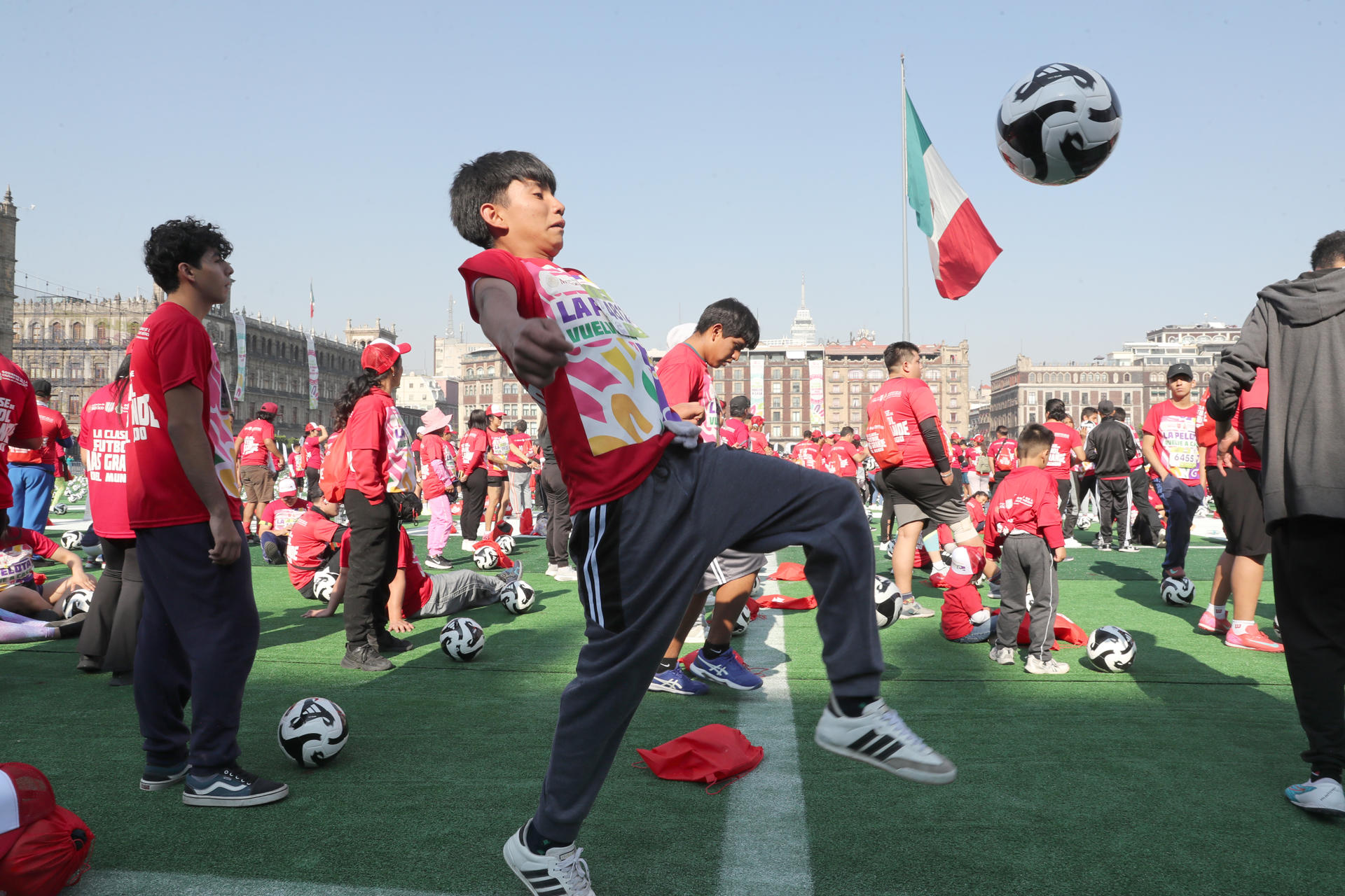 Personas participan en la 'Clase masiva de Fútbol', en busca de imponer un nuevo Récord Guinness en la explanada del Zócalo este domingo, en Ciudad de México (México). EFE/Mario Guzmán