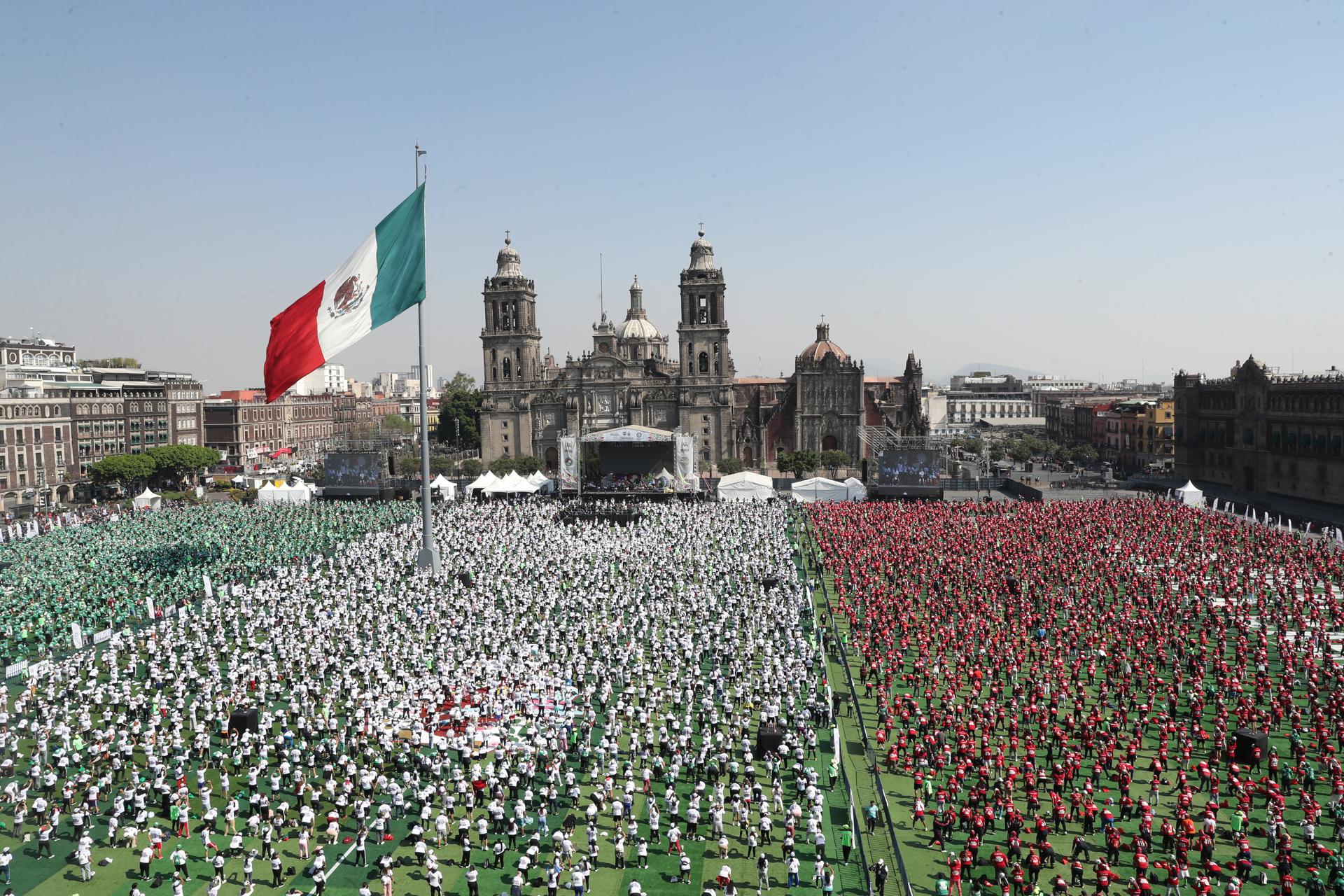 Personas participan en la 'Clase masiva de Fútbol', en busca de imponer un nuevo Récord Guinness en la explanada del Zócalo este domingo, en Ciudad de México (México). EFE/Mario Guzmán